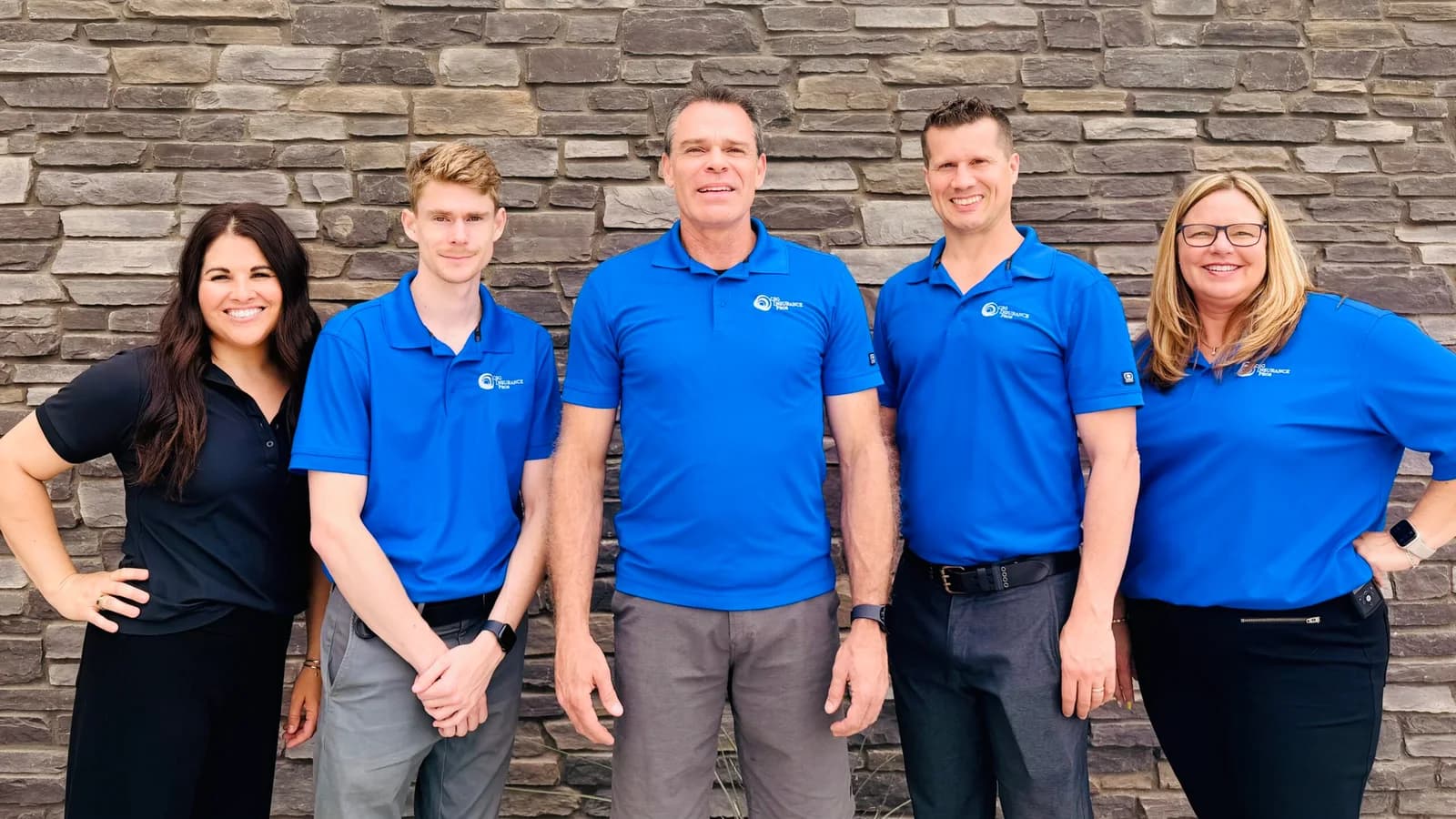 El equipo de cinco personas de CSG Insurance Pros con camisas polo azules de la marca